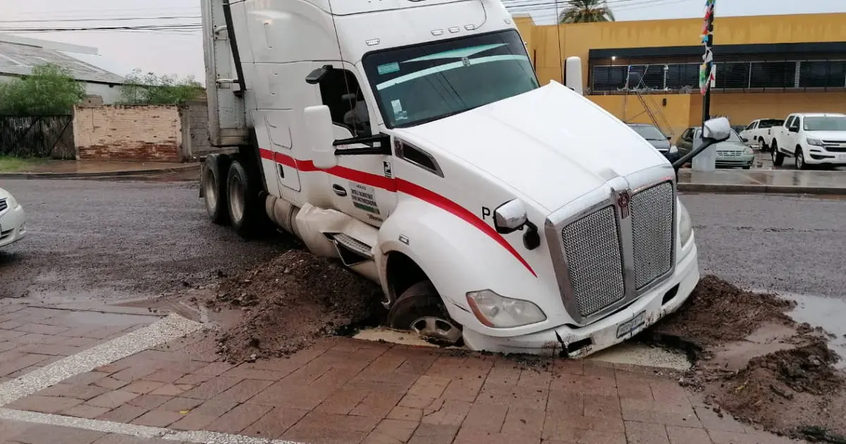 Tráiler cae en socavón y queda varado