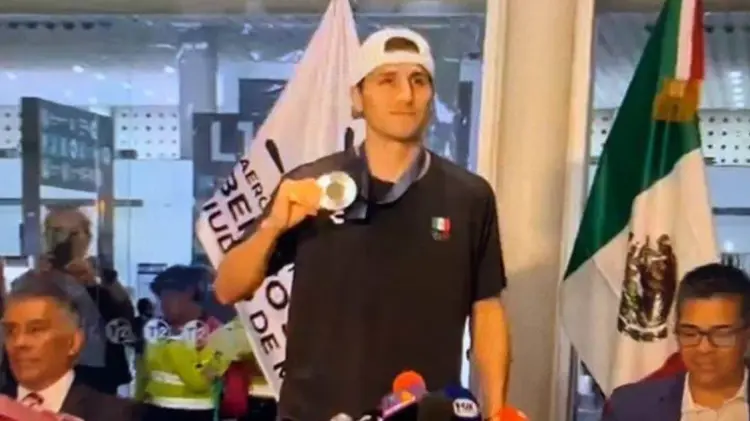 Marco Verde presumió su medalla de plata ante los presentes en el aeropuerto. (Foto: Captura de video)