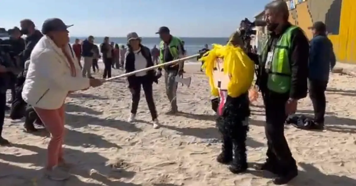 Migrantes golpean piñata de Donald Trump en protesta frente a muro fronterizo